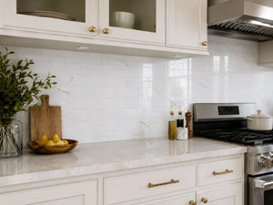 Carrara white marble peel and stick tile installed as kitchen backsplash behind stove – Colamo