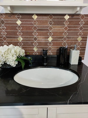 Full view of mid-century geometric peel and stick backsplash tile above a black countertop sink with decorative flowers and bathroom accessories