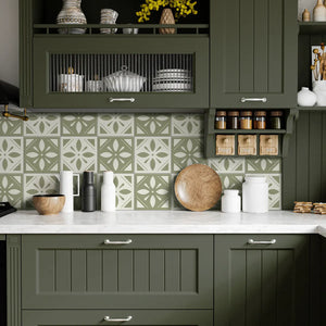 Sage green floral peel and stick tile used as a kitchen backsplash with green cabinets