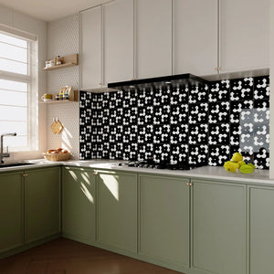 Modern kitchen with Colamo black and white bold floral peel and stick tile backsplash installed behind the stove, featuring sage green cabinets and a high-end DIY remodel look.
