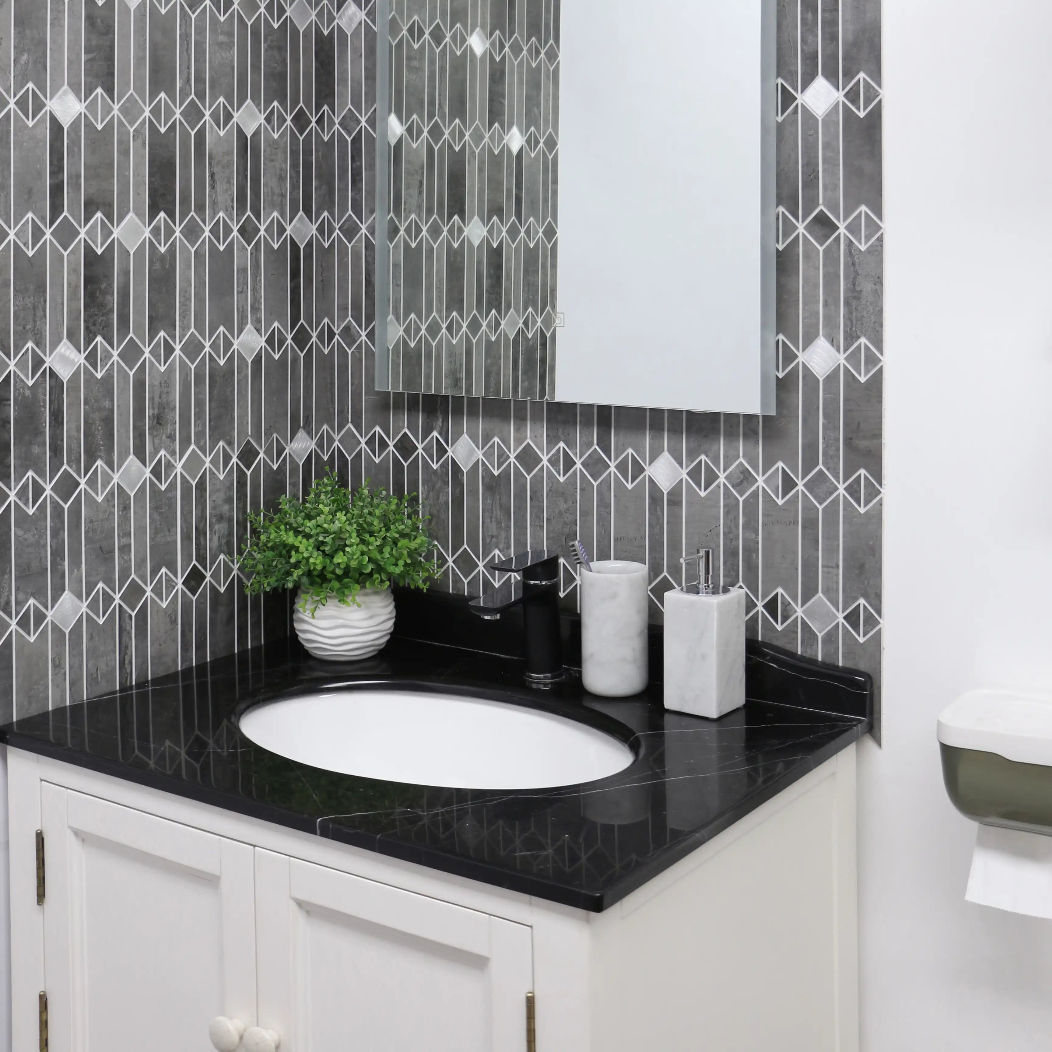 Gray mid-century geometric peel and stick backsplash tile in a modern bathroom vanity with black countertop and white cabinets