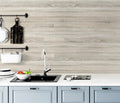 Kitchen with light peel and stick wood look backsplash and white countertop
